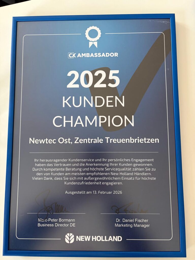Urkunde mit der Überschrift '2025 Kunden Champion' von New Holland, ausgestellt am 13. Februar 2026, mit Text zu Kundenservice und Engagement, unterschrieben von zwei Personen.